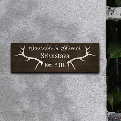 New home name plate with cream antlers, couple names and family name on dark wood