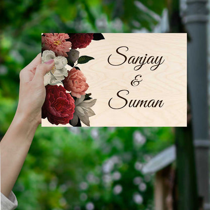Floral peony name plate on an entrance wall with couple names on light wood