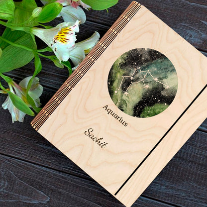 Detail crop on the personalized diary cover, with green-blue-black nebula with Aquarius zigzag-wave, sharp birch grain.