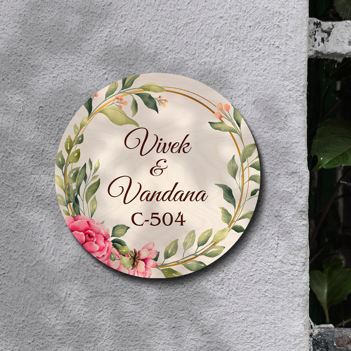 Floral-ring couple name board styled on an entrance wall in soft pastel tones