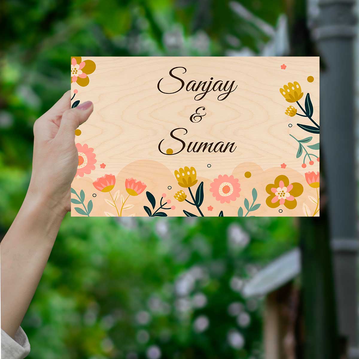 Wooden floral name plate on main door with pink and yellow blooms on cream birch